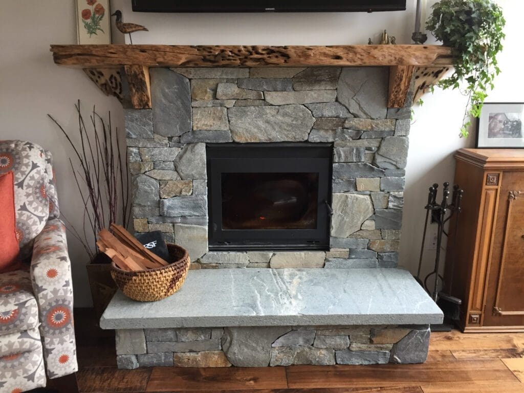 Custom indoor stone fireplace with natural wood mantel, by Central Masonry in Courtenay BC